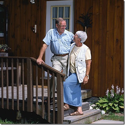 elderly couple in front of house uid 1187314
